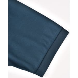 A close-up of a dark teal polo shirt sleeve, featuring a smooth texture and a hemmed cuff.