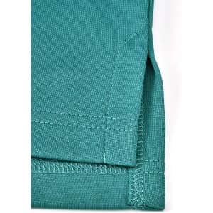 A close-up of a teal men's sustainable poly/cotton polo shirt, featuring a detailed hem and stitching.