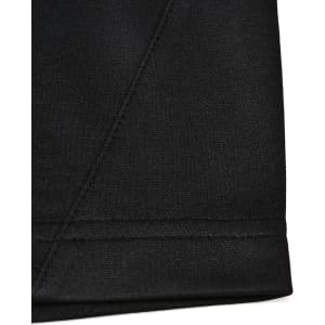 A close-up of a black sustainable poly/cotton polo shirt showing the hem and stitching details. Features a logo.