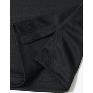 A close-up of a black sustainable jacquard knit polo shirt showcasing the fabric and sleeve design.