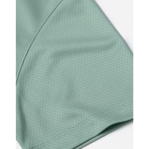 A close-up of a mint green jacquard knit fabric, showcasing its texture and pattern detail.