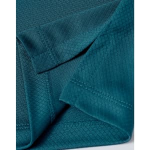 A close-up of a teal fabric featuring a jacquard knit pattern, showing the texture and stitching details.