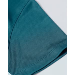 A close-up of a teal jacquard knit fabric featuring a smooth texture and subtle pattern, with a logo present.