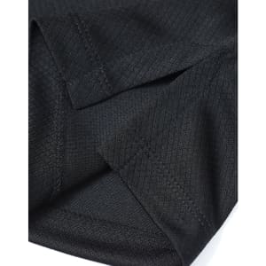 A close-up of a black sustainable jacquard knit polo featuring textured fabric and detailed stitching.