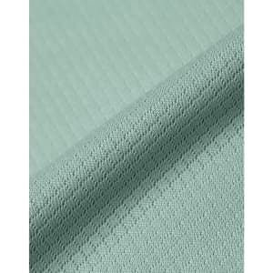A close-up of a textured fabric in light green, showcasing a jacquard knit pattern. The image features a subtle sheen.