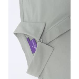 A light green men's polo shirt with a collar, showcasing a tag and button detail. It features branding on the tag.