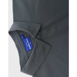 A grey polo shirt featuring a collar and a button, with a tag showing branding.