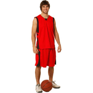 A model wearing red basketball shorts and a matching sleeveless jersey, standing beside a basketball.