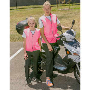 Two individuals wearing bright pink hi-vis safety vests stand next to a scooter. The setting appears to be outdoors.