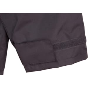 A close-up of a black safety jacket featuring a Velcro patch and reflective 3M tape accents.