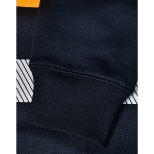 A close-up of a navy blue jumper with a striped design and ribbed cuffs, featuring a logo.