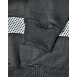 A close-up of a dark green jumper featuring a grey striped pattern and ribbed cuffs, with a branding logo.