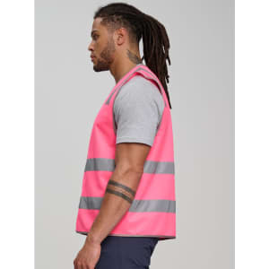 A pink safety vest with grey reflective tapes, worn by a man with long hair, showcasing side view design.