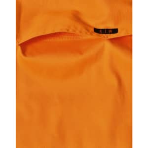 An orange work shirt featuring a pocket and a tag with a logo.