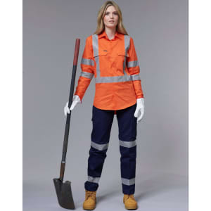 An orange work shirt with reflective stripes, paired with navy pants and work boots, held by a woman with a shovel.