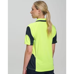 A woman wearing a high-visibility yellow and navy safety polo shirt, featuring a logo on the chest and back.