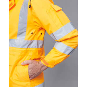 A bright yellow safety jacket with reflective stripes, featuring a pocket and adjustable cuffs. It has a logo.
