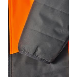 A close-up of a hi-vis quilted safety jacket featuring orange and dark grey colours, with a focus on the sleeve detail.