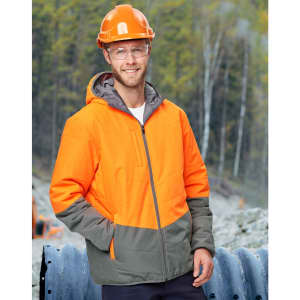 A Hi-Vis quilted two-tone safety jacket in orange and grey, worn by a man in a hard hat and safety glasses, outdoors.