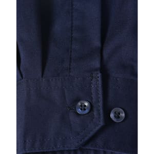A close-up of a blue long-sleeve shirt featuring segmented tape, with a buttoned cuff detail.