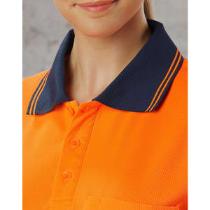 A close-up of a unisex orange polo shirt with a navy blue collar and three buttons, featuring a logo.
