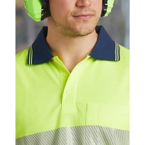 A close-up of a unisex, long-sleeve, high-visibility polo shirt in vibrant yellow with a navy collar and a pocket.