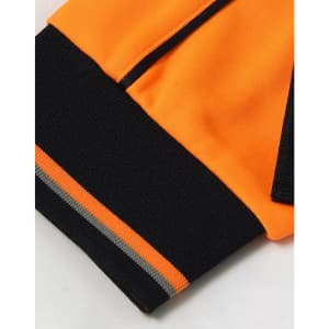 A close-up of an orange and black long-sleeve polo shirt featuring a logo and contrasting cuffs.
