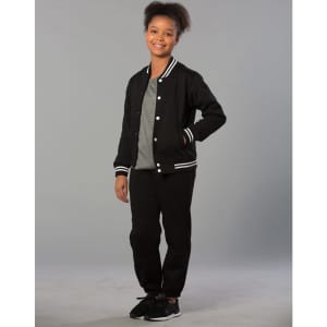 A girl is wearing black fleecy track pants with zips, cuffs, and knee padding, paired with a grey T-shirt and black jacket.