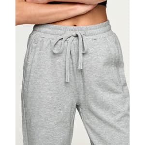 Grey unisex sweatpants with an elastic waistband and drawstring, featuring side pockets and a logo.
