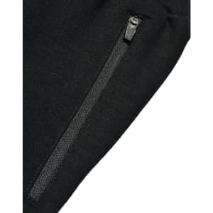 A close-up of black kids' poly/cotton terry sweat pants featuring a zippered pocket.