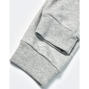 A pair of grey poly/cotton terry sweat pants with ribbed cuffs. The image highlights the fabric texture.