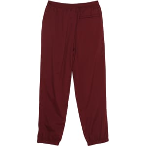 Burgundy track pants with an elastic waistband and cuffs, featuring a logo on the side.