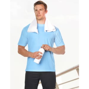 A man stands holding a white drink bottle, wearing a light blue short sleeve tee and a towel draped around his neck.