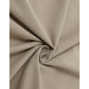 A close-up of soft, beige cotton fabric, showcasing its smooth texture and drape.