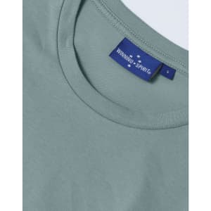 A close-up of a men's premium cotton short-sleeve T-shirt in a soft green hue, featuring a branded label.