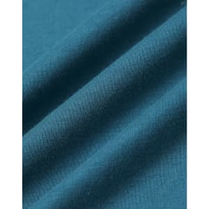 A close-up of a textured fabric in deep teal, showcasing the softness and weave of the premium cotton material.