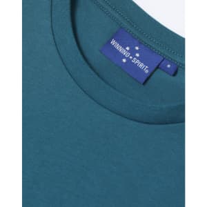 A close-up of a teal women's premium cotton t-shirt featuring a round neckline and a stitched label.