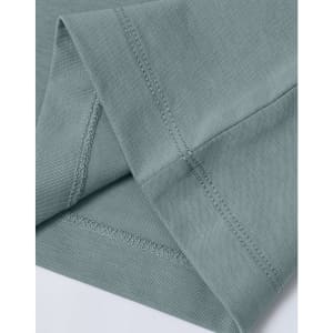 A close-up of a light green premium cotton T-shirt, highlighting the sleeve and stitching details.