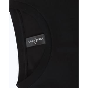 A close-up of a black long-sleeve tee with a round neckline, featuring a branded label inside the collar.