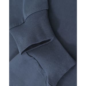 A close-up of navy blue cotton long sleeve tee shirt cuffs, featuring a subtle logo.