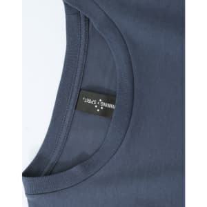 A close-up of a dark grey ladies' long-sleeve cotton tee shirt with a tag and a rounded neckline.