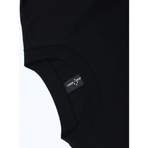 A black unisex heavy cotton oversized tee featuring a tag with branding on the inner neckline.