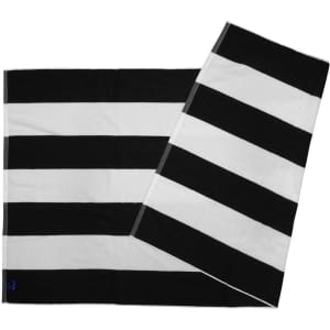 A striped beach towel in black and white with a logo, featuring alternating bold stripes.