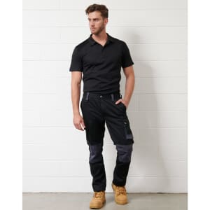 A black short-sleeve polo shirt worn with dark trousers and work boots, featuring a logo on the shirt.