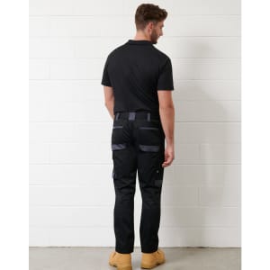 Unisex black utility stretch cargo work pants with grey accents and multiple pockets, displayed on a model from the back.