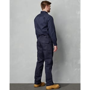 A person wearing navy cargo pants with side pockets and a matching shirt, standing against a textured background.