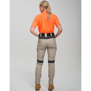 Rip-stop poly/cotton stretch work pants in beige, featuring a logo, worn with an orange shirt. View from the back.