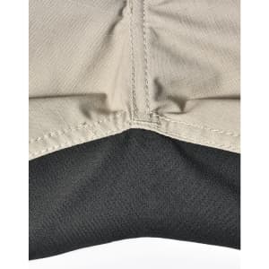 A close-up of Rip-Stop poly/cotton stretch work pants, featuring a beige upper section and a black lower section with stitching.