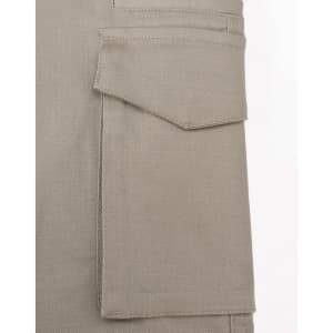 A close-up of a beige work pant pocket featuring a flap, showcasing the fabric texture and stitching detail.
