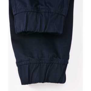 A pair of navy unisex cotton stretch drill cuffed work pants with gathered cuffs. Features a logo on the waistband.